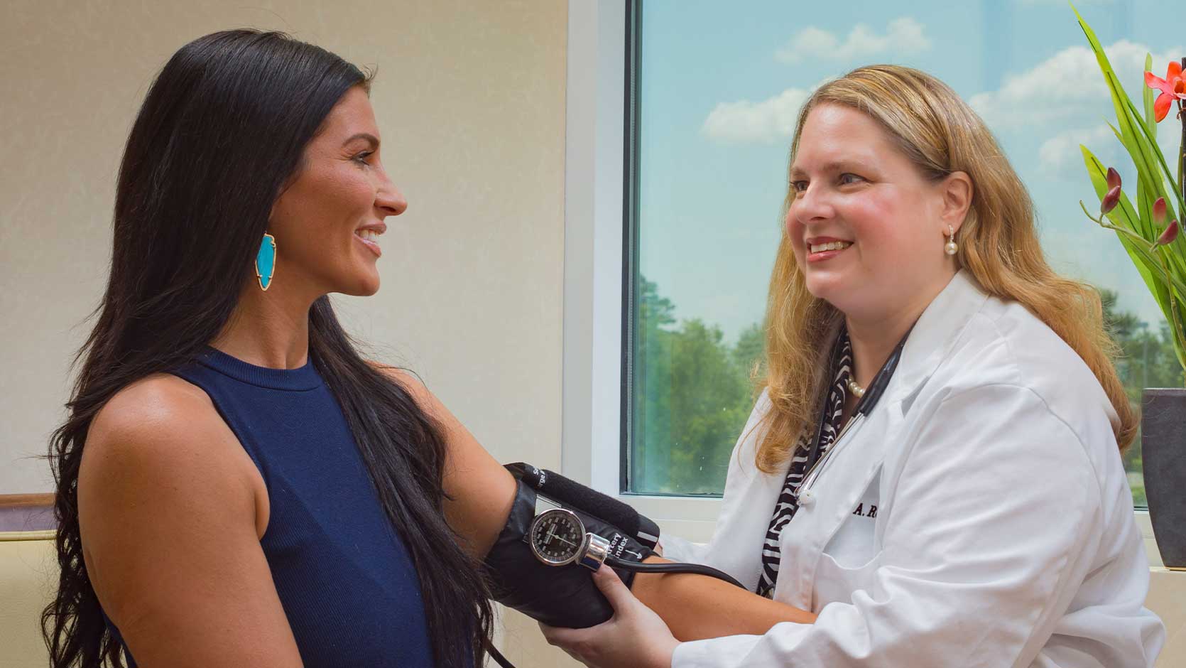 A female gynecologist checking a woman's blood pressure.